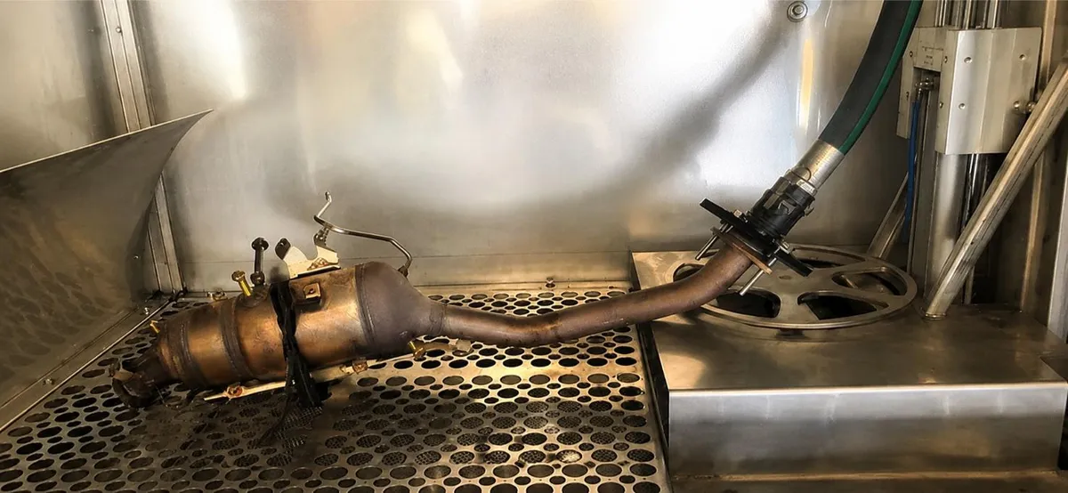 Diesel particulate filter and downpipe mounted in the wash cabinet ready for cleaning
